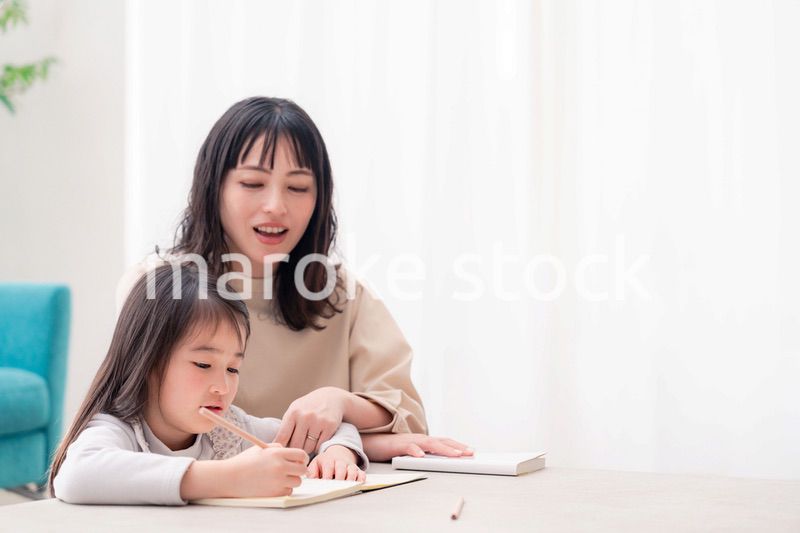 幼稚園児の女の子と一緒に勉強をするお母さん
