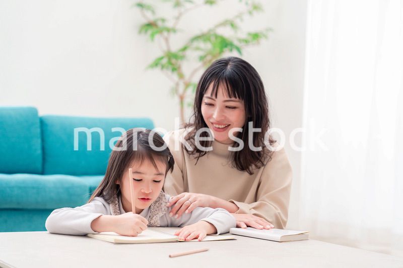 幼稚園児の女の子と一緒に勉強をするお母さん