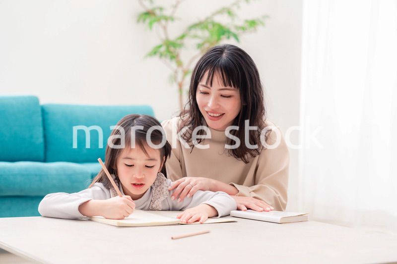 幼稚園児の女の子と一緒に勉強をするお母さん