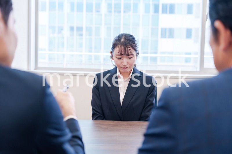 オフィスで上司に詰められて悲しい表情をする女性社員