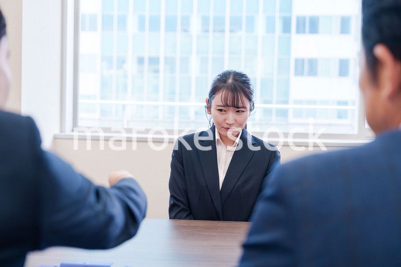 オフィスで上司に詰められて悲しい表情をする女性社員