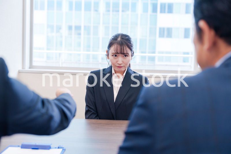 オフィスで上司に詰められて悲しい表情をする女性社員