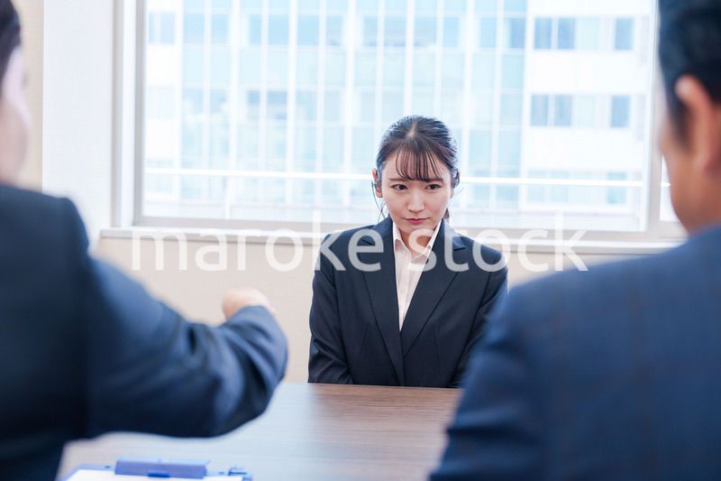 オフィスで上司に詰められて悲しい表情をする女性社員