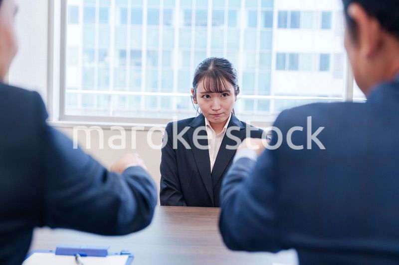 オフィスで上司に詰められて悲しい表情をする女性社員