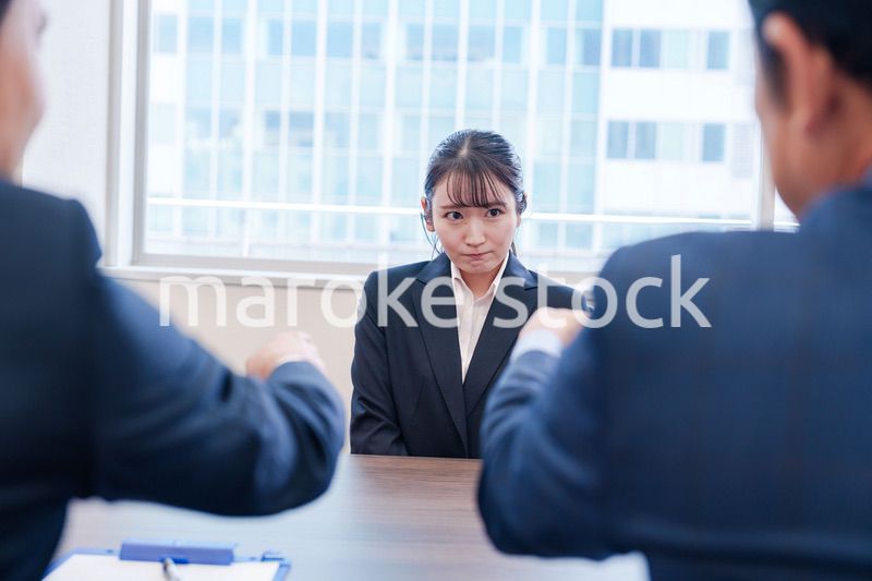 オフィスで上司に詰められて悲しい表情をする女性社員