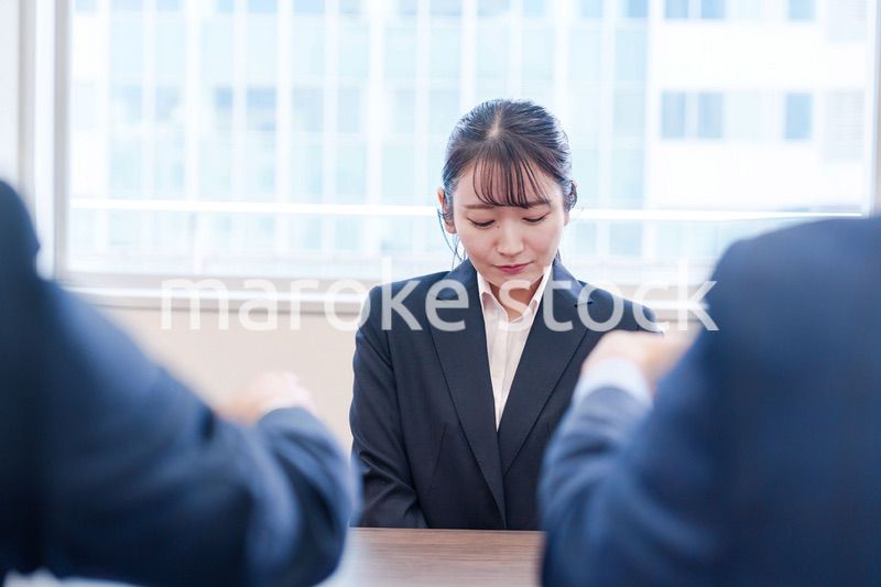 オフィスで上司に詰められて悲しい表情をする女性社員