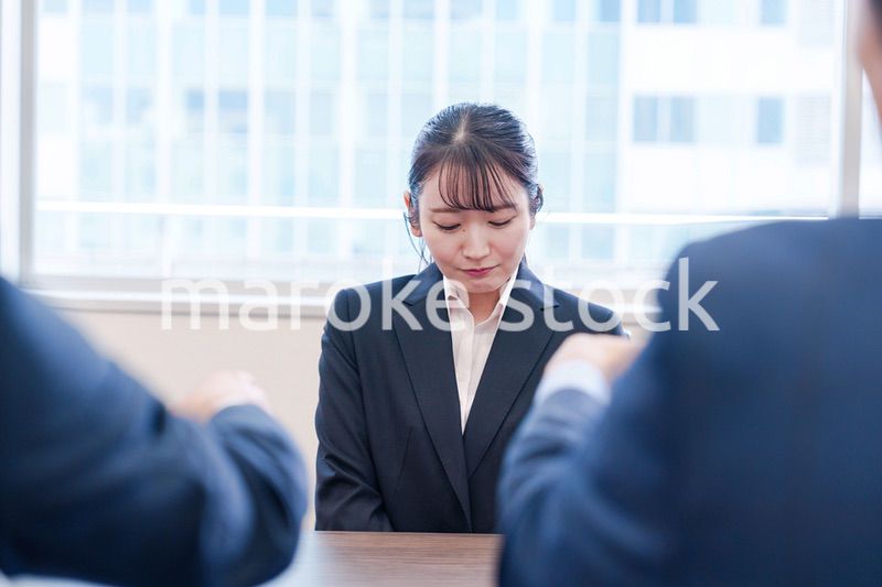 オフィスで上司に詰められて悲しい表情をする女性社員