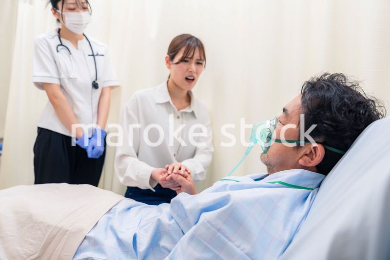 人工呼吸器をつけた家族のお見舞いをする若い女性