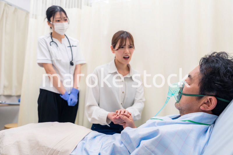 人工呼吸器をつけた家族のお見舞いをする若い女性