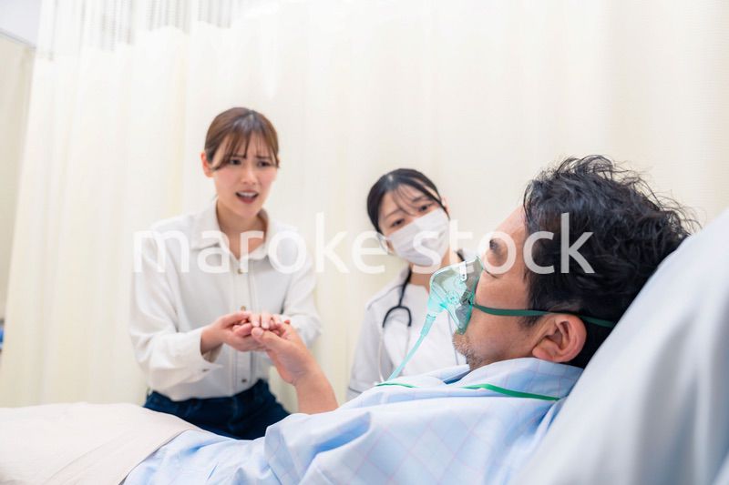 人工呼吸器をつけた家族のお見舞いをする若い女性