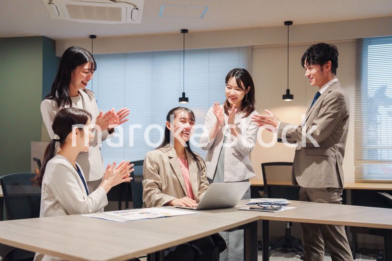 オフィスメンバーから拍手喝采される女性社員