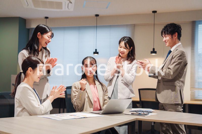オフィスメンバーから拍手喝采される女性社員
