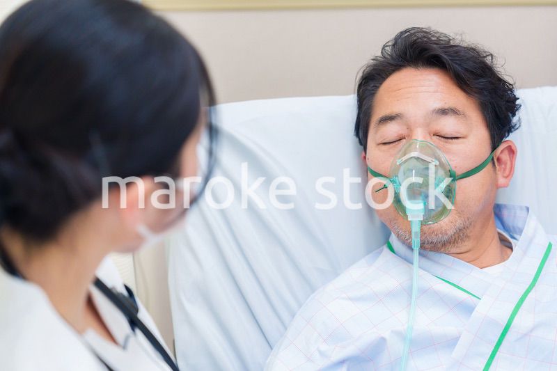 人工呼吸器をつけて話をする入院患者の男性