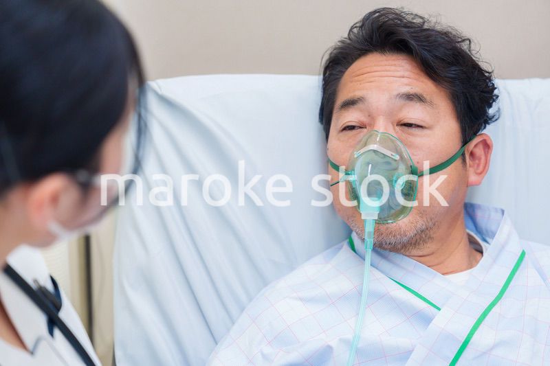 人工呼吸器をつけて話をする入院患者の男性