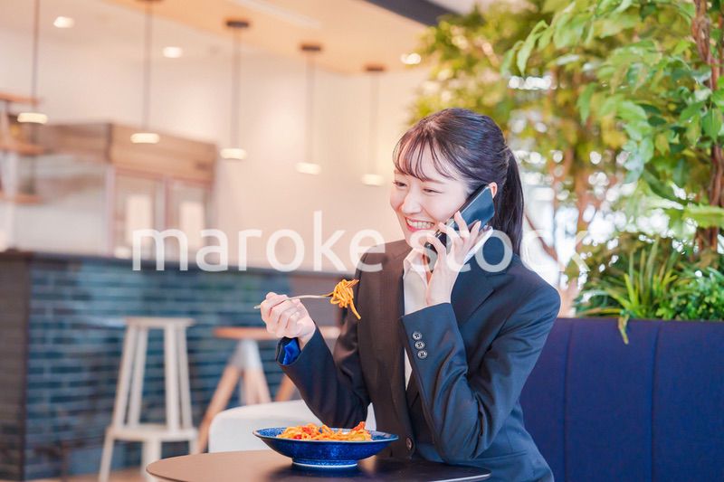 スマホで笑顔で電話をする就活生の女性