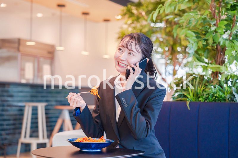 スマホで笑顔で電話をする就活生の女性