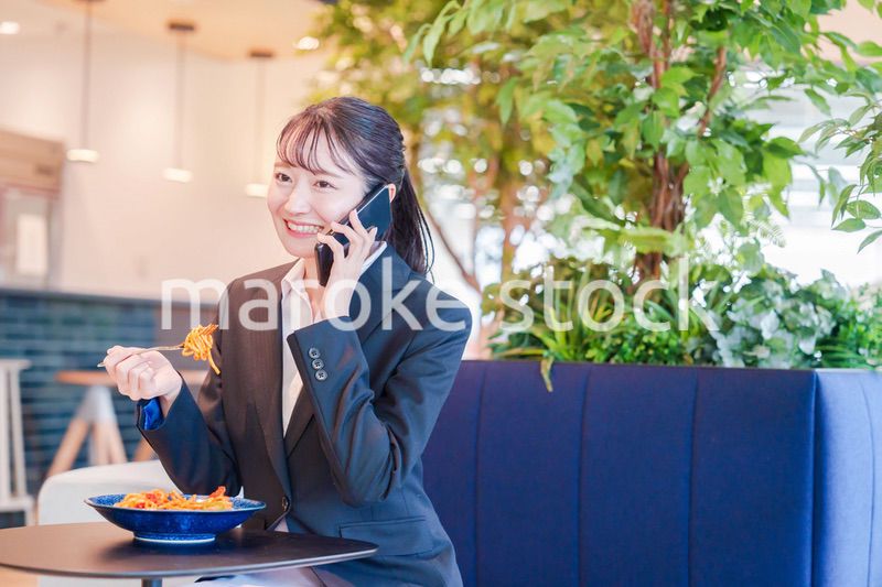 スマホで笑顔で電話をする就活生の女性