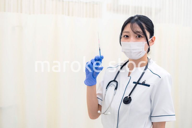 注射器を持つ若い女性の医療従事者