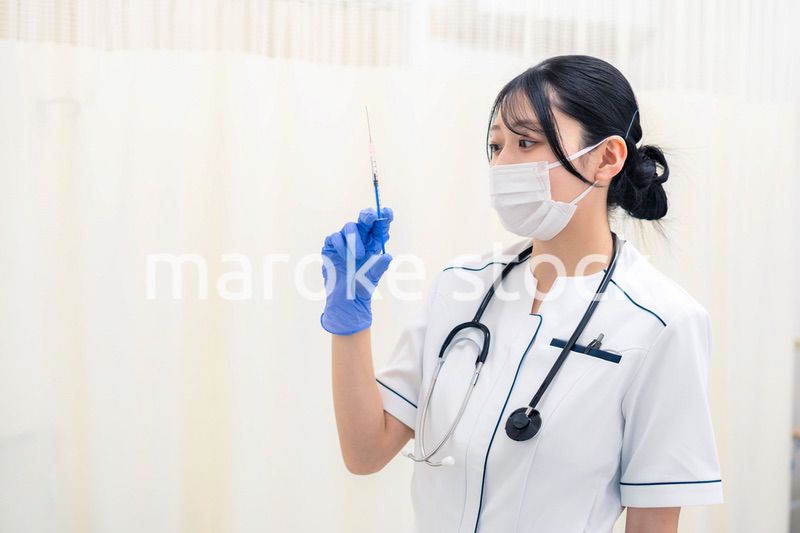 注射器を持つ若い女性の医療従事者