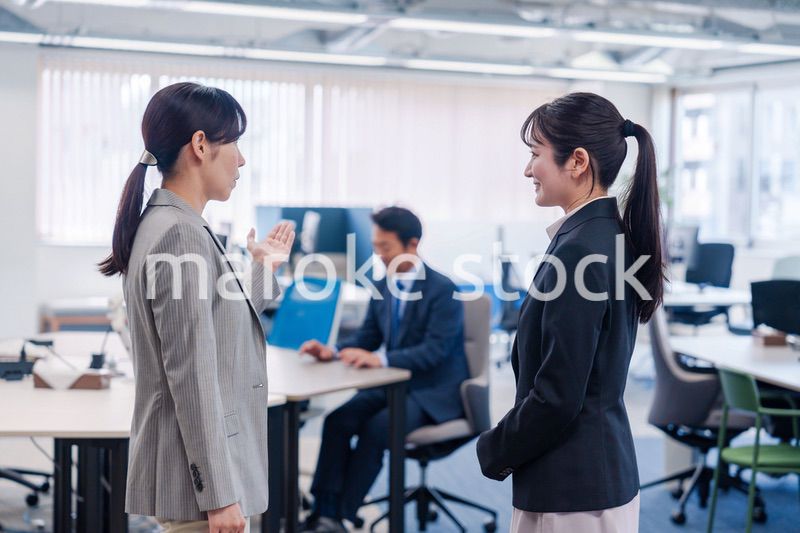 先輩社員にオフィスを案内してもらうフレッシュな女性