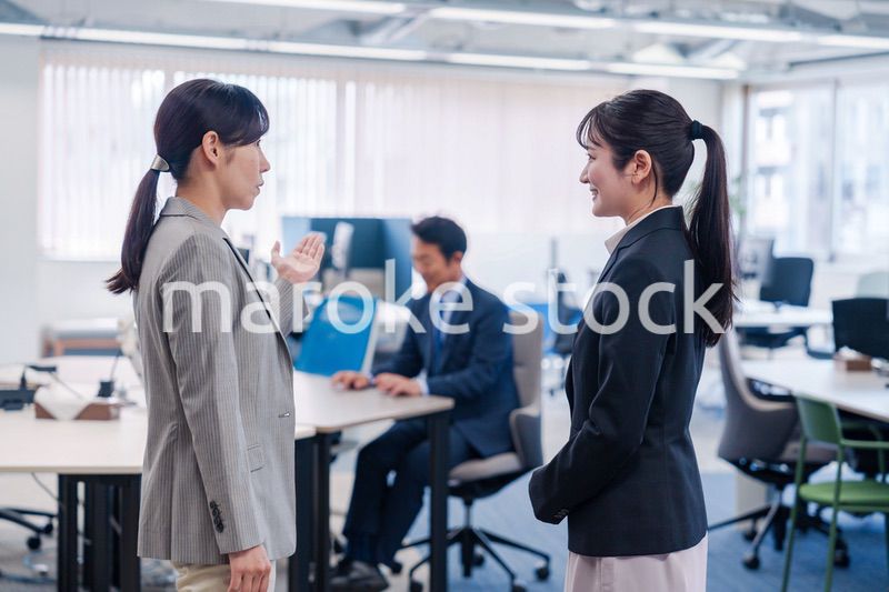 先輩社員にオフィスを案内してもらうフレッシュな女性