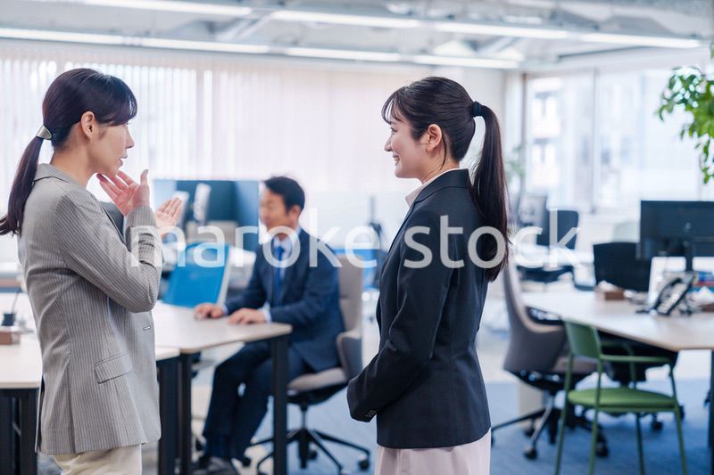 先輩社員にオフィスを案内してもらうフレッシュな女性