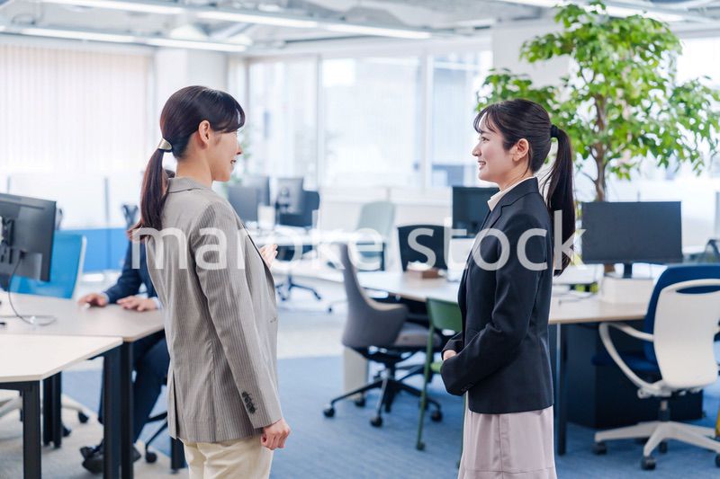 先輩社員にオフィスを案内してもらうフレッシュな女性