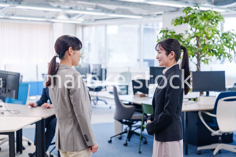 先輩社員にオフィスを案内してもらうフレッシュな女性