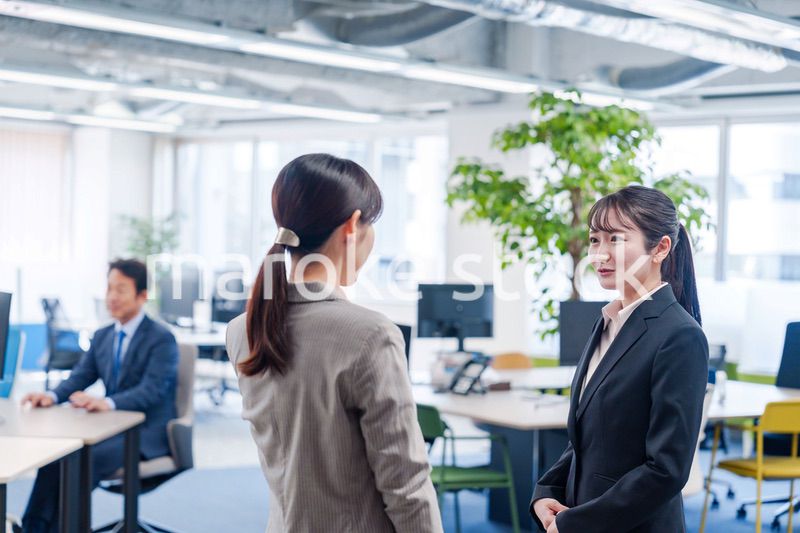 先輩社員にオフィスを案内してもらうフレッシュな女性