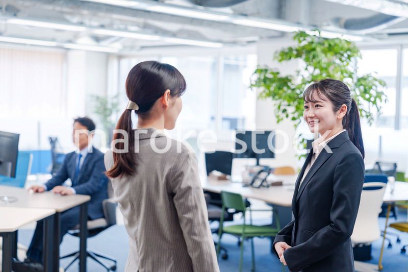 先輩社員にオフィスを案内してもらうフレッシュな女性