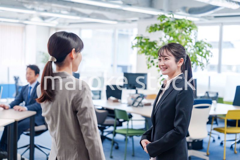 先輩社員にオフィスを案内してもらうフレッシュな女性