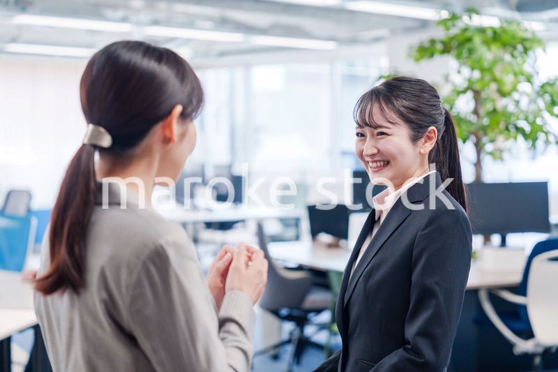 先輩社員にオフィスを案内してもらうフレッシュな女性