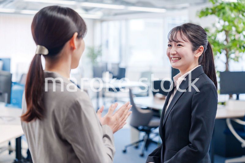 先輩社員にオフィスを案内してもらうフレッシュな女性