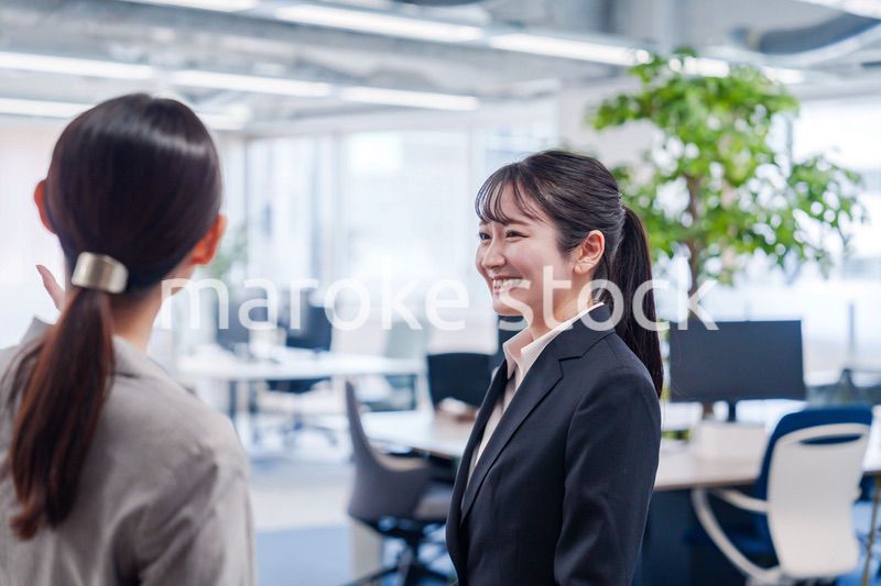 先輩社員にオフィスを案内してもらうフレッシュな女性