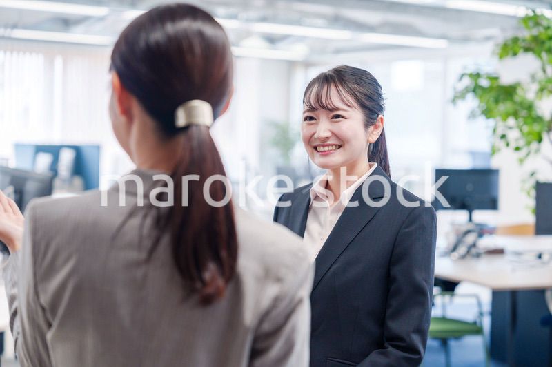 先輩社員にオフィスを案内してもらうフレッシュな女性