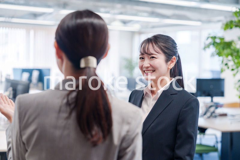 先輩社員にオフィスを案内してもらうフレッシュな女性