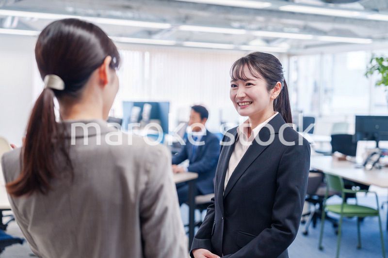 先輩社員にオフィスを案内してもらうフレッシュな女性