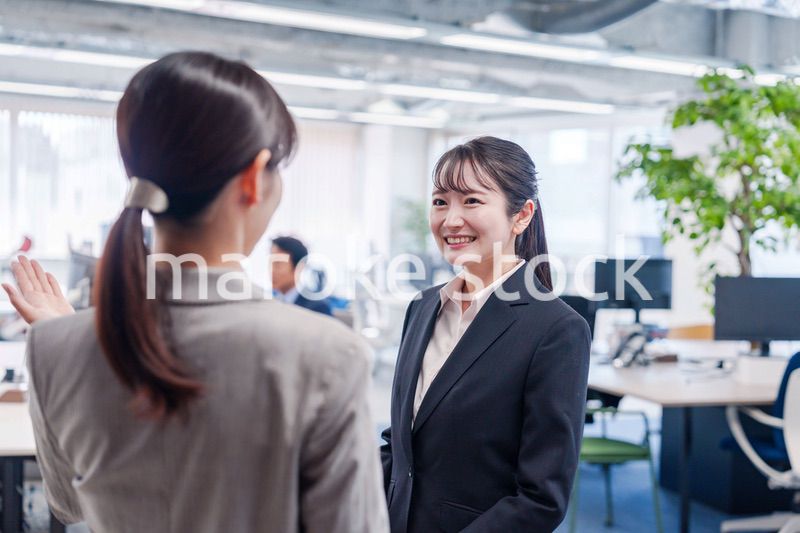 先輩社員にオフィスを案内してもらうフレッシュな女性