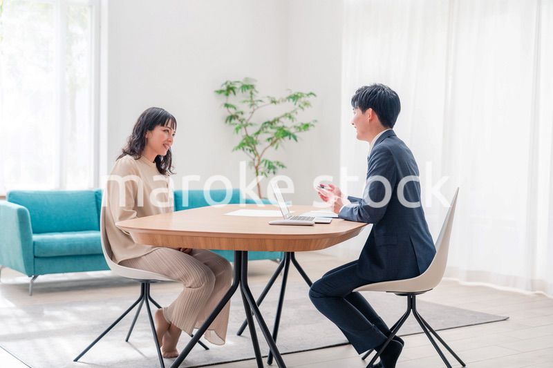 家のリビングを訪問し営業をする男性のビジネスマン