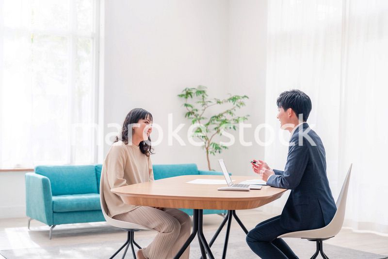 家のリビングを訪問し営業をする男性のビジネスマン