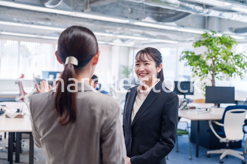 先輩社員にオフィスを案内してもらうフレッシュな女性