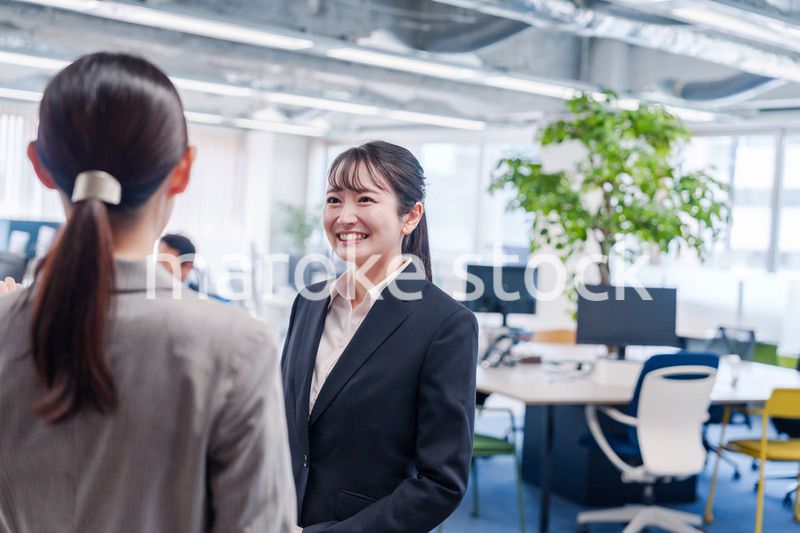先輩社員にオフィスを案内してもらうフレッシュな女性