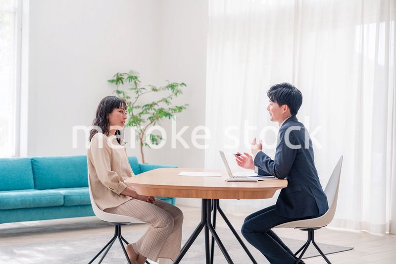 家のリビングを訪問し営業をする男性のビジネスマン