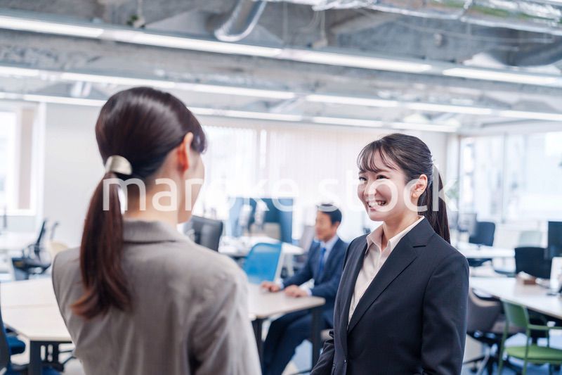 先輩社員にオフィスを案内してもらうフレッシュな女性