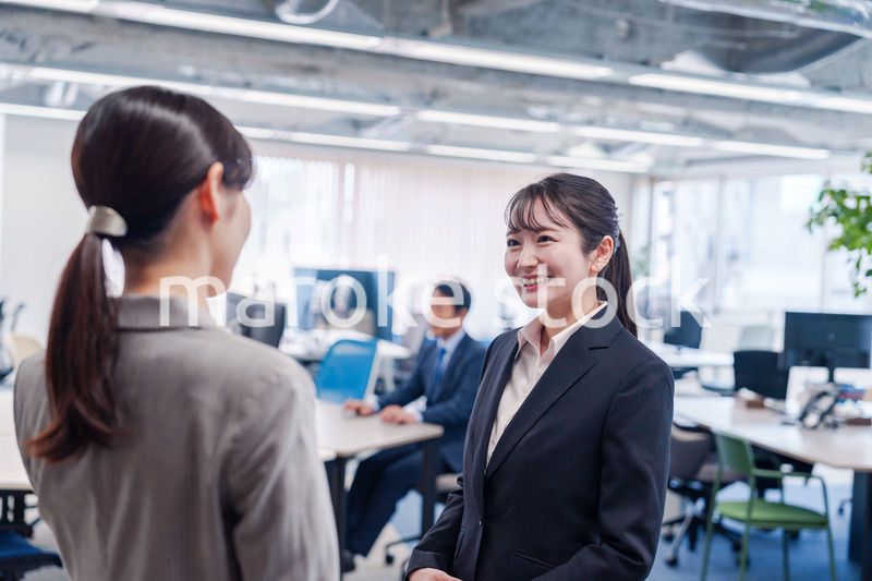 先輩社員にオフィスを案内してもらうフレッシュな女性