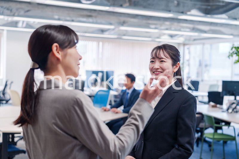 先輩社員にオフィスを案内してもらうフレッシュな女性