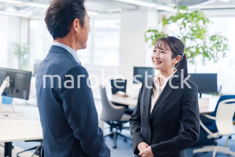 笑顔で上司と話をする若いビジネスウーマン