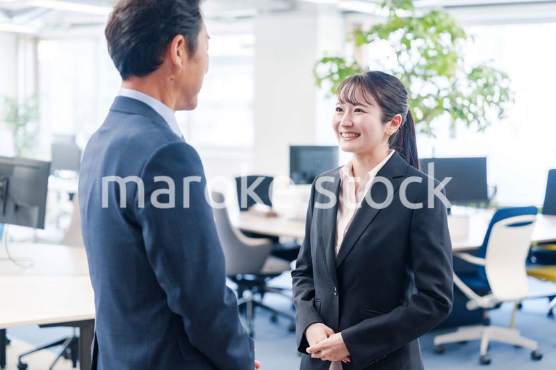 笑顔で上司と話をする若いビジネスウーマン