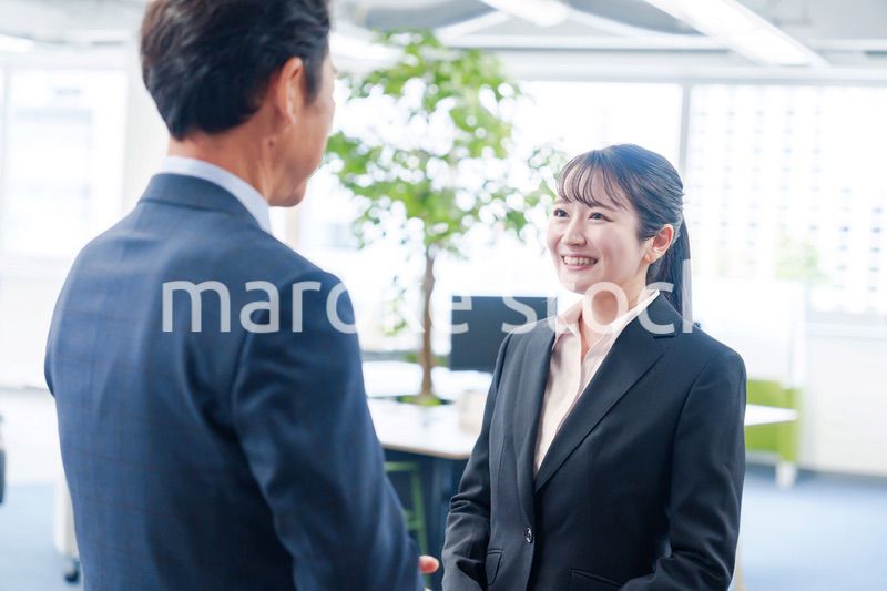 笑顔で上司と話をする若いビジネスウーマン