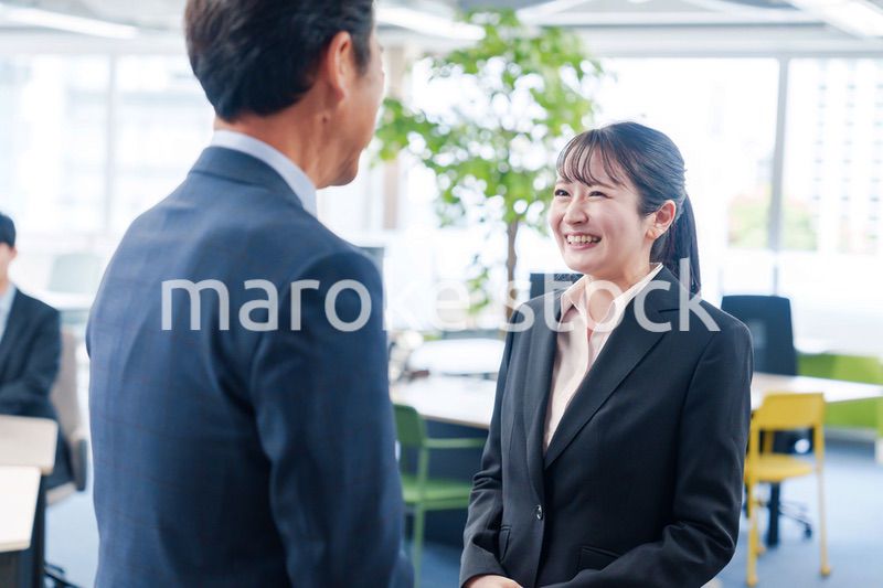 笑顔で上司と話をする若いビジネスウーマン
